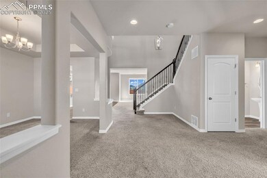 Entryway with light colored carpet, stairs, a chandelier, and recessed lighting