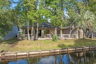Back of property with a water view and a yard