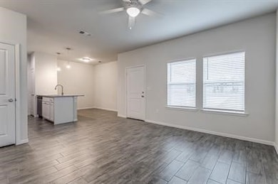 Unfurnished living room with dark wood-type flooring and ceiling fan