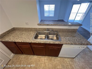 Kitchen featuring healthy amount of natural light, a peninsula, white dishwasher, and dark stone counters