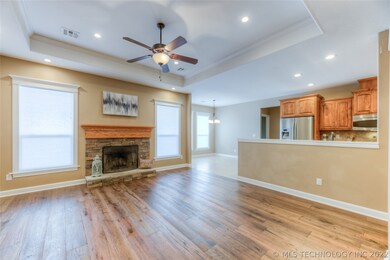 living room with wood burning FP open to kitchen