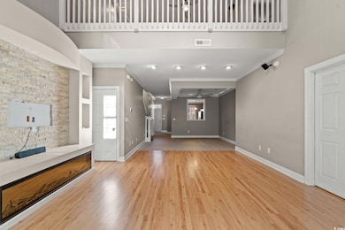 Unfurnished living room with crown molding, ceiling fan, healthy amount of natural light, baseboards, and light wood finished floors