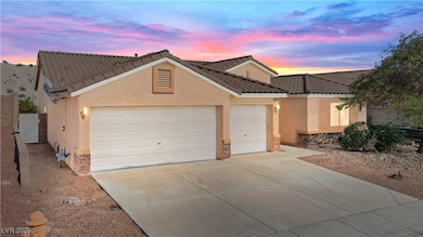 View of front facade featuring stone siding, concrete driveway, and stucco siding