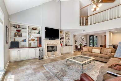 Den with cathedral ceiling, built-ins and stone fi
