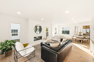 Living room featuring recessed lighting, light wood flooring, and an electric modern fireplace