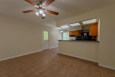 Unfurnished living room with a ceiling fan and ba