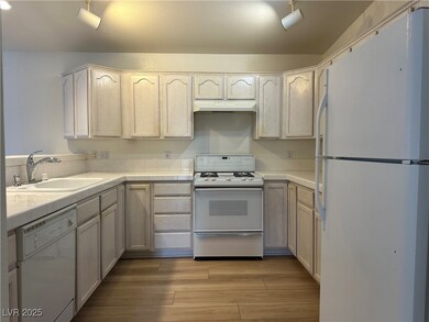 Kitchen featuring white appliances, a sink, under