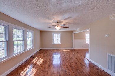 Spacious Living Room/Family Rm with Ceiling Fan.  Hardwood floors were just refinished, new windows, ceiling fan and whole room freshly painted!  Open to the Dining Room off the kitchen. 