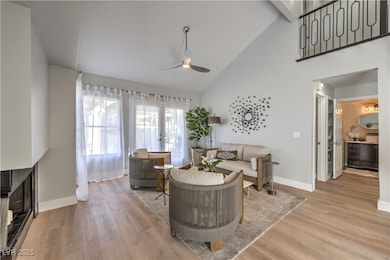 Living room featuring ceiling fan, light wood-type