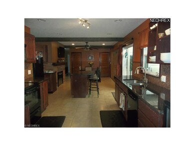 Over sized kitchen has granite counters and island