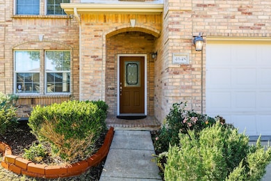 View of exterior entry with a garage and brick siding