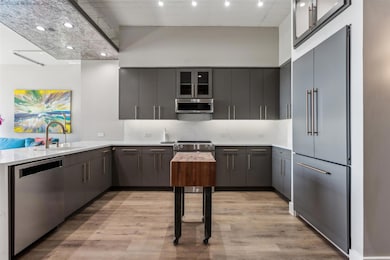 Kitchen featuring gray cabinets, light hardwood / 