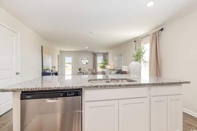 Kitchen featuring a sink, white cabinetry, open fl