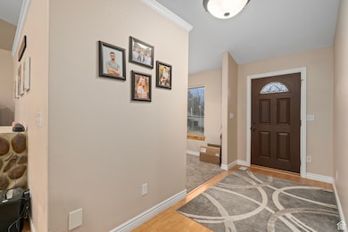 Foyer entrance with light wood finished floors and baseboards