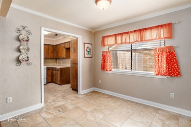 Unfurnished dining area with ornamental molding and light tile patterned flooring