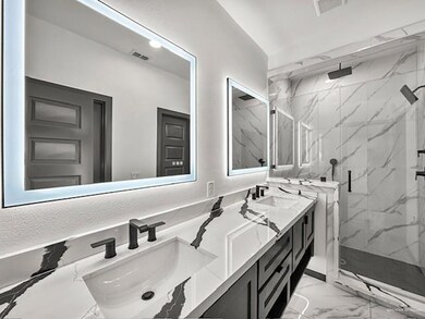 Bathroom with walk in shower, double vanity, and tile patterned flooring