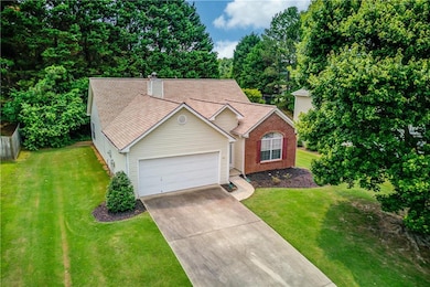 View of front of home with an attached garage, driveway, a chimney, and roof with shingles