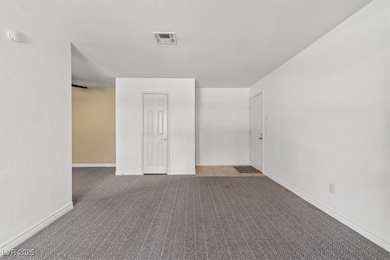 Carpeted spare room featuring baseboards