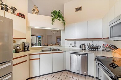 Kitchen featuring ceiling fan, sink, white cabinet