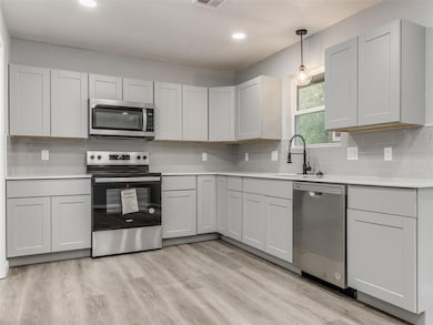 Kitchen with decorative backsplash, appliances wit