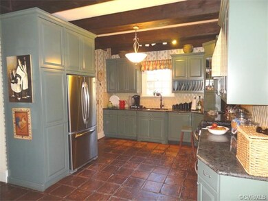 Gourmet kitchen with exposed beams, granite counter tops, and mexican tile floor