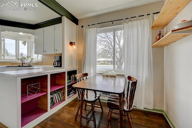 Dining area featuring dark wood-style flooring, a 