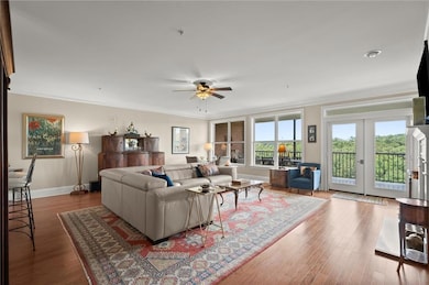 Living room featuring ornamental molding, a ceiling fan, wood finished floors, and baseboards