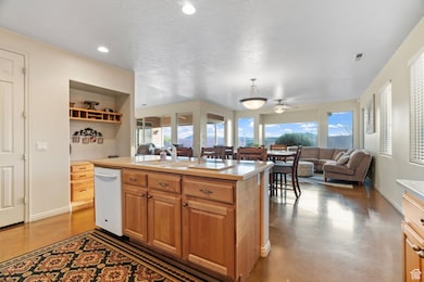 Kitchen featuring dishwasher, a kitchen island with sink, plenty of natural light, and concrete floors
