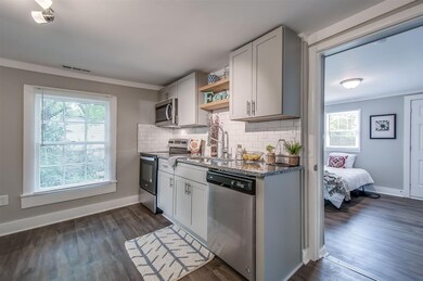 Close up view of the kitchen showing the granite counters and subway-tiled backsplash.