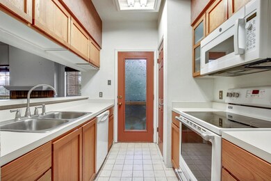 Kitchen with white appliances, light countertops,