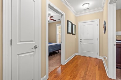 Entryway featuring light wood-style flooring, crown molding, and ceiling fan