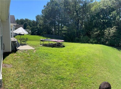 View of spacious backyard featuring a concrete patio