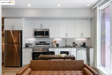Kitchen featuring appliances with stainless steel finishes, dark countertops, white cabinets, decorative backsplash, and open floor plan
