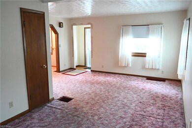 Living room with a textured ceiling and carpet flo