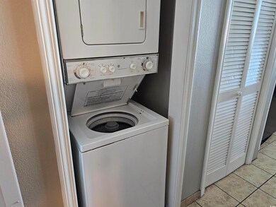 Laundry room with stacked washer and clothes dryer