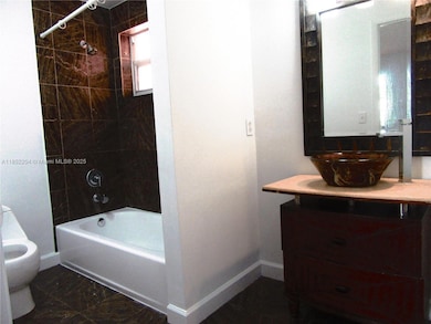 Main bathroom decorated with marble and glass sink bowl.