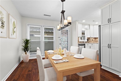 Dining area with baseboards, dark wood-type floori