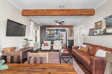 Living room featuring crown molding, beam ceiling, ceiling fan, and dark wood-style floors