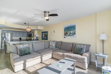 Living room with ceiling fan and light hardwood / 