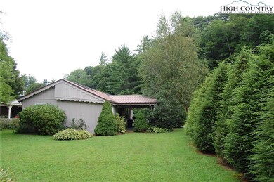 Rear view showing large back yard with Hemlocks as