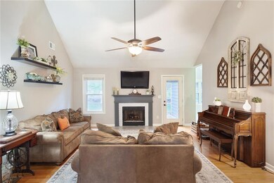 Living room with ceiling fan, a tiled fireplace, l