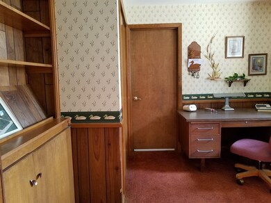 Adjoining office with built-ins and access to garage.