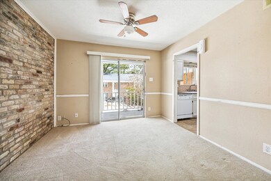 DINING ROOM WITH BRICK ACCENT WALL AND ACCESS TO T