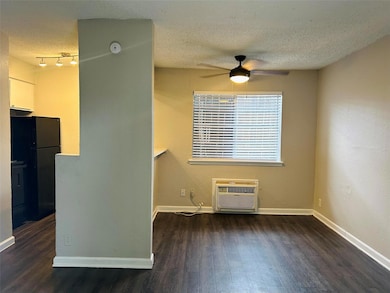 Empty room featuring a wall mounted AC, ceiling f