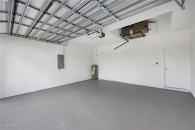 Garage with electric panel, water heater, and a garage door opener