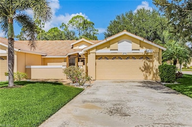 View of front of house featuring a tiled roof, stucco siding, a front lawn, driveway, and a garage