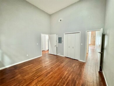 Large Bedroom w/ high ceilings & wood accent wall.