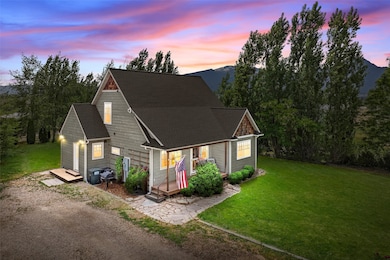 View of front facade with a wooden deck, a yard, and a shingled roof