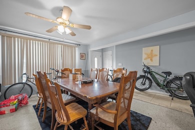 Dining room with speckle patterned floor and ceiling fan