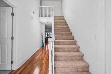 Foyer Stairway Entry with wood finished floors and baseboards